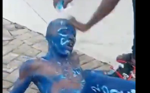 man painted in NPP colors to beg for money