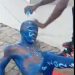 man painted in NPP colors to beg for money